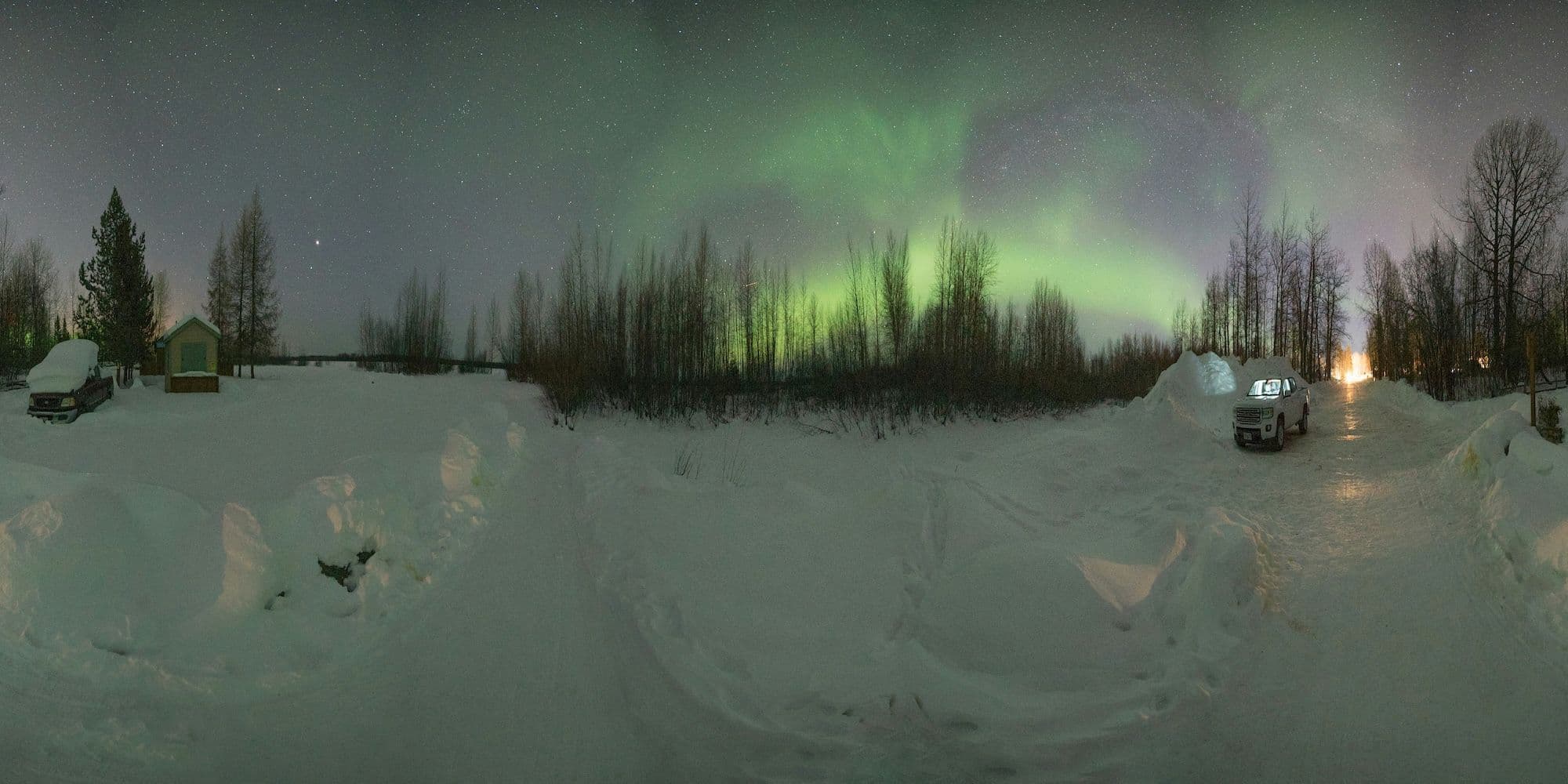 A 360 degree photo of a northern landscape with aurora borealis in the background.